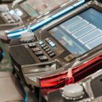 Detailed view of illuminated slot machines in a casino, showcasing vibrant screens and controls.